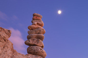 Fototapeta na wymiar Object of stones on the background of the night sky and the moon. Zen stones. Harmony & Meditation