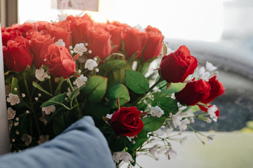 A bouquet of red roses beside the sofa