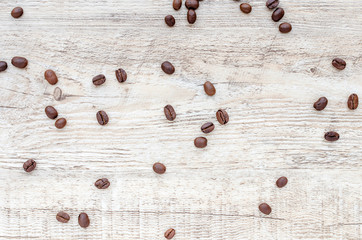 Roasted coffee beans on wooden texture background.