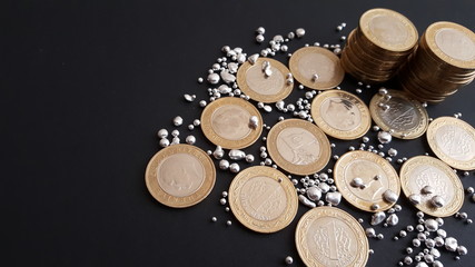 silver grains and coins on a black background