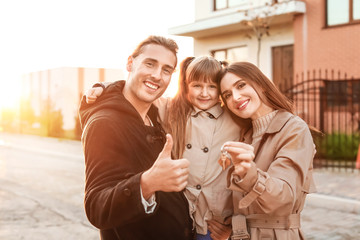 Young family with key near their new house