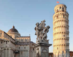 View of the Cathedral, the Leaning Tower of Pisa and a wonderful medieval monument - Fountain dei Putti (Fountain with Angels) with the coat of arms of Pisa, Italy.