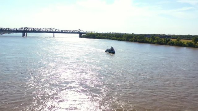 Good aerial of a paddlewheel steamboat riverboat moving up the Mississippi River with Memphis Tennessee in the background.