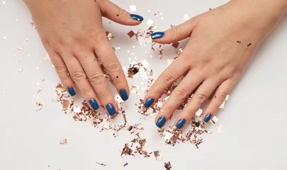 Foto op Canvas Female hand with trendy manicure in classic blue color. Color of the year 2020. © Alona