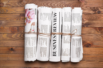 Many newspapers on wooden background