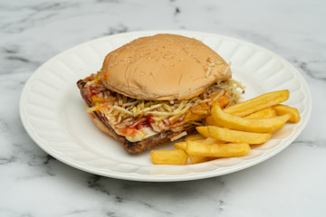 Hamburger with meat, tomato, lettuce and french fries.