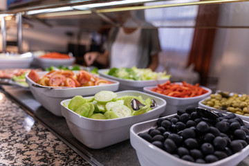 Detail of dishes with chopped and prepared vegetables in a self-service restaurant