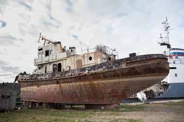 Fototapeta premium Rusty decommissioned marine ship that was left on the shore.