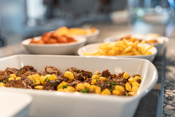 Meat and potato stew tray with other food trays