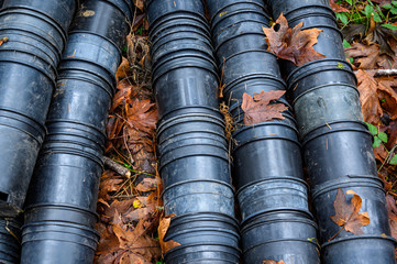 Collection of black plastic cultivation pots after young plants have been replanted in the forest, ready for recycling