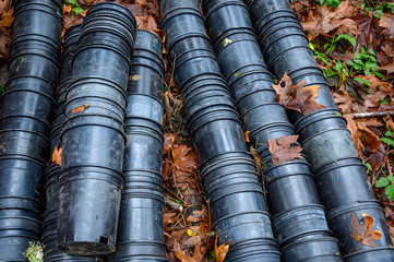 Collection of black plastic cultivation pots after young plants have been replanted in the forest, ready for recycling