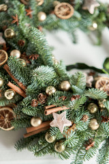 Closeup details of Beautiful Christmas wreath of fresh spruce on the white door. Entrance to the house. Christmas mood. Xmas tree.