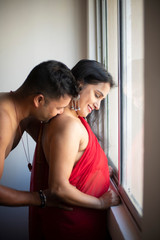 An young and handsome Indian brunette Bengali man trying to  kiss his partner/girlfriend/wife  from...