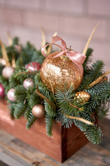 Closeup details of Small arrangement of fresh spruce in a rustic wooden box. Christmas mood. Bokeh of Garland, lamps lights on background.