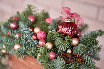 Closeup details of Small arrangement of fresh spruce in a rustic wooden box. Christmas mood. Bokeh of Garland, lamps lights on background.