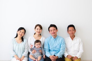  子供を抱っこして座っている3世代家族