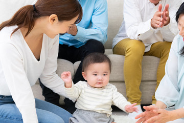 泣いている子供をあやす家族