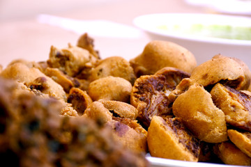 Crispy onion bhajis or kanda or pyaj ke pakore or pakoda , delicisous indian and brazilian street food on salad, typically enjoyed in rainy / monsoon season with hot tea, selective focus