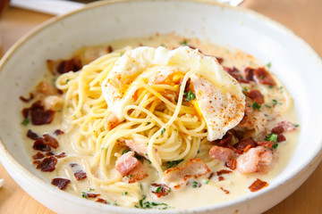 Pasta cream sauce with bacon and poached egg