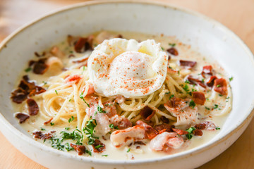 Pasta cream sauce with bacon and poached egg