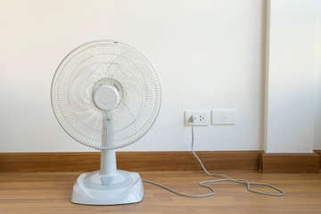 Table electric fan sit on the wooden floor - obrazy, fototapety, plakaty