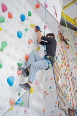 Fototapeta na wymiar A man climbs up on a climbing wall.