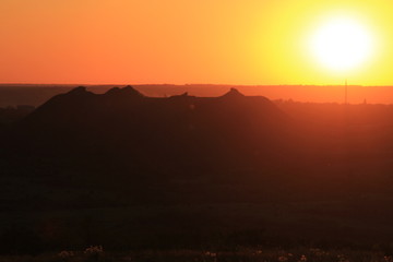 The red sun sets over the horizon.