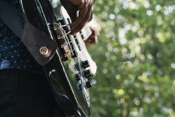Portrait of African musician bass guitar player outdoors