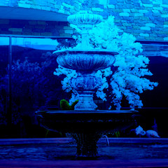 Fountain with three bowls high shutter speed to freeze water driop down, blue water. Horizontal. Architecture and decoration. Classic, blue monochrome, trend 2020