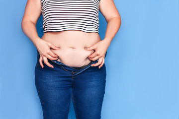 Fat woman in jeans showing her excess weight.