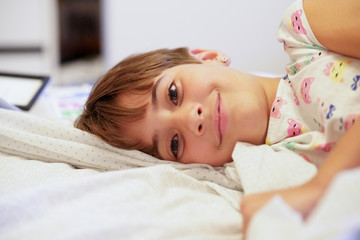 Little girl, eight years old, lying on her bed