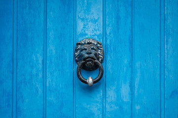 Lion-shaped knocker on blue doors