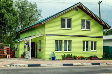 Lovely green wooden house on the highway in the city. Close-up.