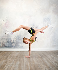 Flexible cute little girl child gymnast doing acrobatic exercise - obrazy, fototapety, plakaty