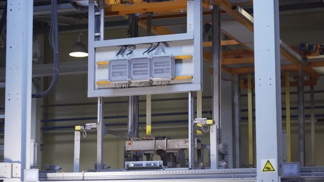 Aluminum profiles are immersed in a special solution with help girder crane. The anodizing. The process of anodizing of aluminum in the enterprise. Metal processing.