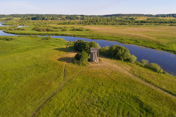 Old wooden windmill on the banks of the Sorot river on a sunny June morning (aerial photography)....