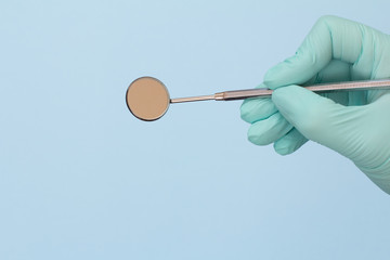 Dentist's hand in glove with mouth mirror.