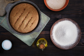 Fresh bread, sourdough for baking homemade bread, rye flour, salt, water and butter on a sarm wooden table.