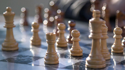 Backlit chess board with white pawn in focus and excellent bokeh
