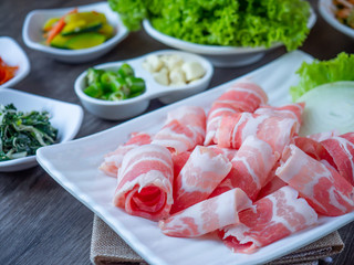 Set of raw fresh pork slide in white plate serve with many kind of vegetable.