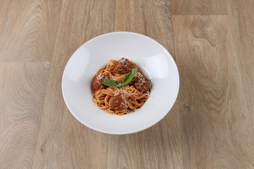 gourmet spaghetti and meatballs - pasta on white plate - wooden background - isolated