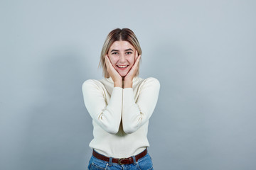 Attractive young woman in casual sweater over isolated on gray wall background studio portrait,...