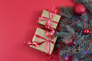 Gifts near the Christmas tree on a red background. Red Christmas balls.