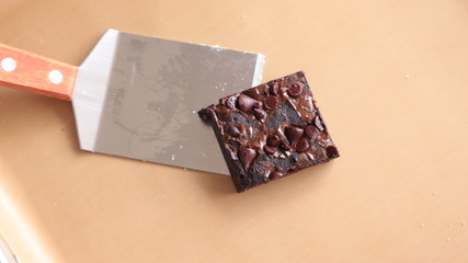 Chocolate brownies placed on a baking tray are beautifully arranged.