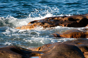Sydney Australia, gentle waves breaking over rocks in Sydney Harbour