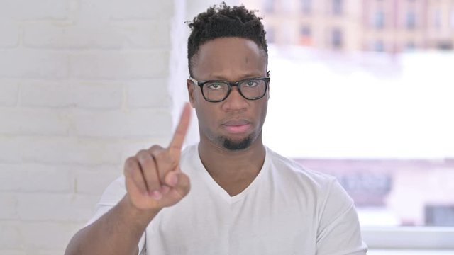 Portrait of Casual African Man saying No with Finger Gesture 