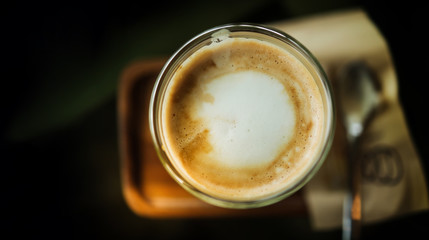 Closeup of Hot Coffee Latte in Cup on Table. Top View. Cafe or Restaurant Scene