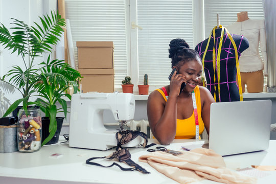woman fashion designer with afro pigtails dreadlocks working on her home atelier