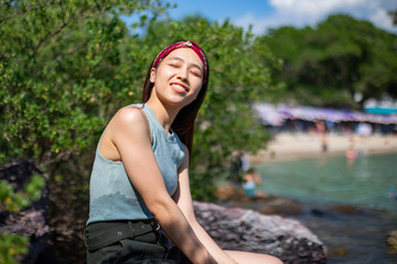 Portrait of sexy slim woman sitting on rock with beautiful seascape background, Woman sitting on seaside