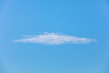 Strange small white cloud on the clear blue sky. and look like alien ufo.